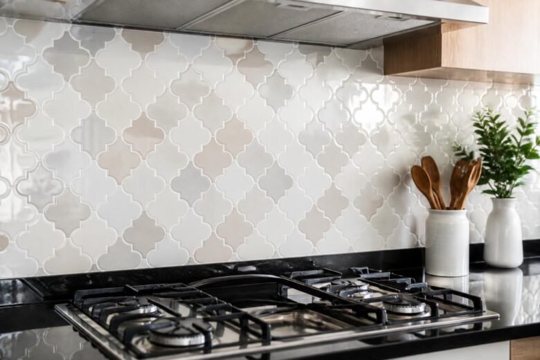 Azulejo de cozinha limpo e brilhante atrás do fogão, sem gordura