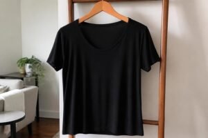 Roupa preta bem conservada, cor intensa, pendurada em cabide